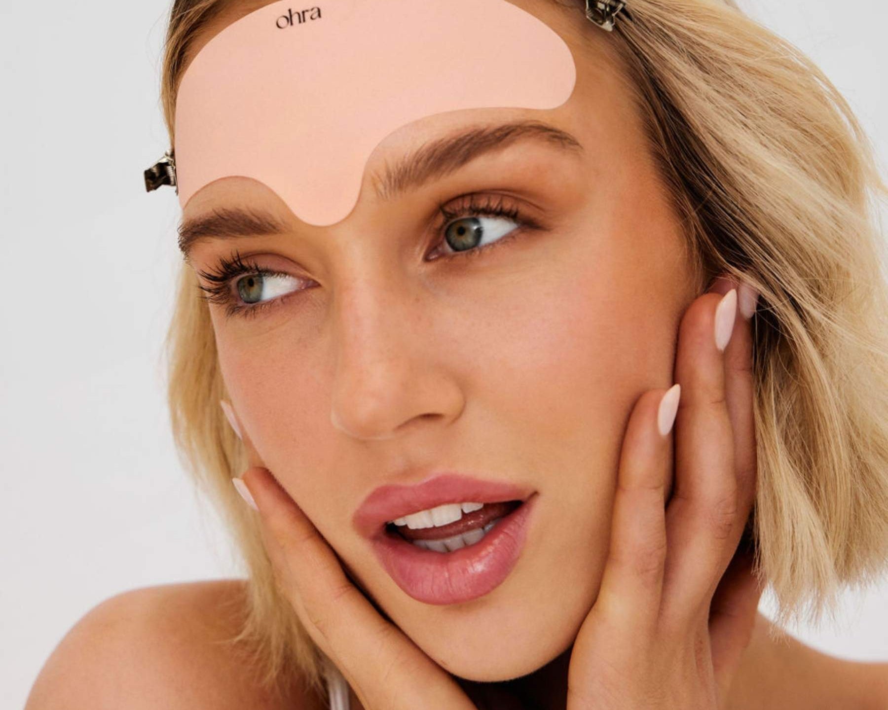 Woman applying the Ohra Lifted Forehead Mask during her skincare routine to smooth and soften fine lines