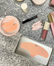 The Full Set flat lay, Self Made Eye Mask, Untouched Hair Clips, and Lifted Forehead Mask styled with makeup on granite