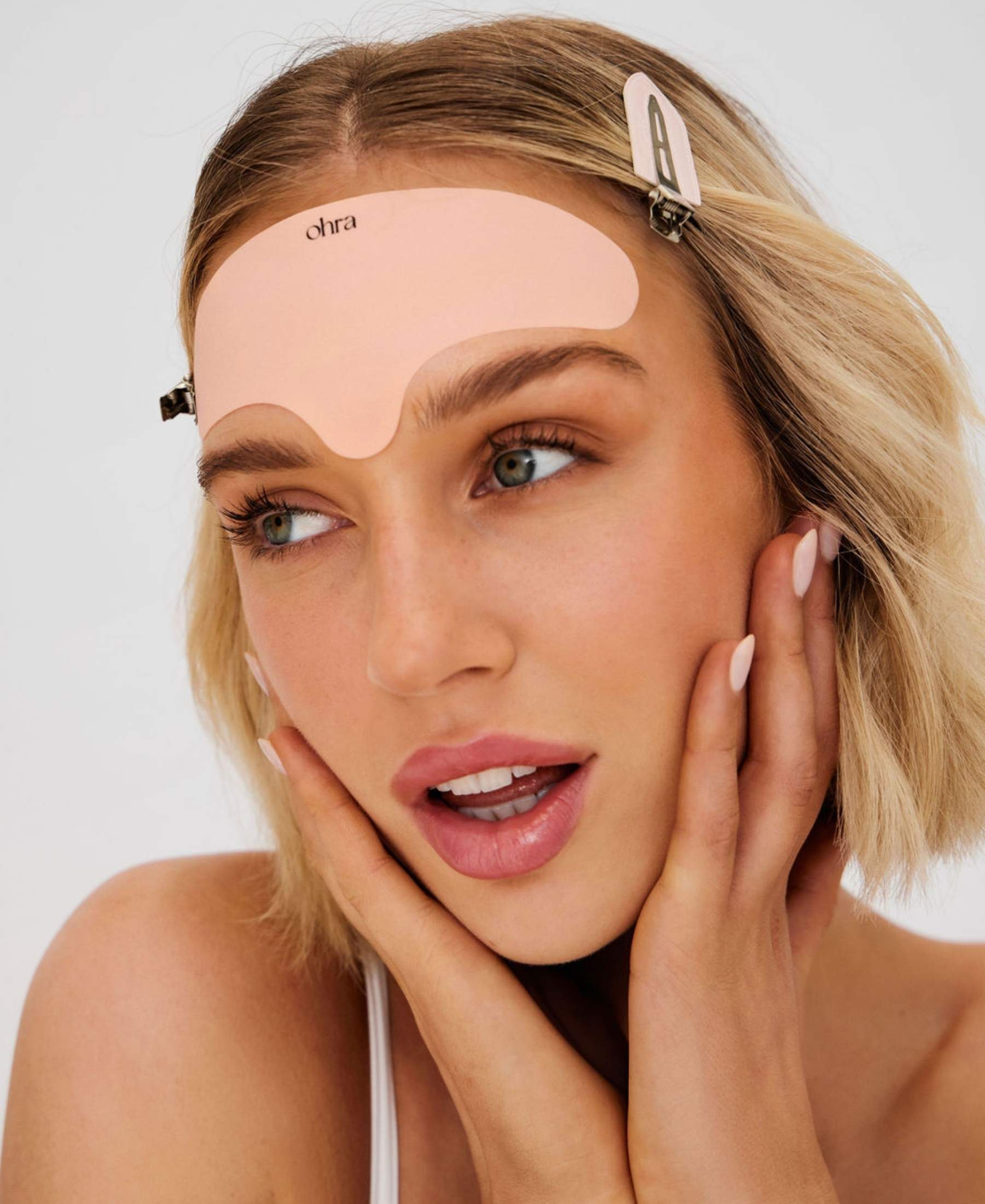 Woman applying the Ohra Lifted Forehead Mask during her skincare routine to smooth and soften fine lines