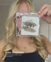 Video of a woman applying Ohra Untouched Hair Clips in Smokey during her makeup routine